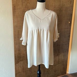 Cream colored oversized blouse.